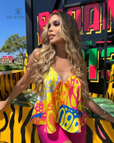 Mujer luciendo una blusa estampada colorida con tirantes finos, ideal para un look vibrante y alegre. Perfecta para destacar en cualquier ocasión.