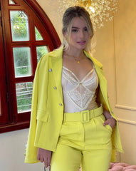 Conjunto de traje amarillo con blazer y pantalón, combinado con un delicado top blanco de encaje. Perfecto para un look sofisticado y moderno, ideal para eventos especiales y para destacar con estilo.