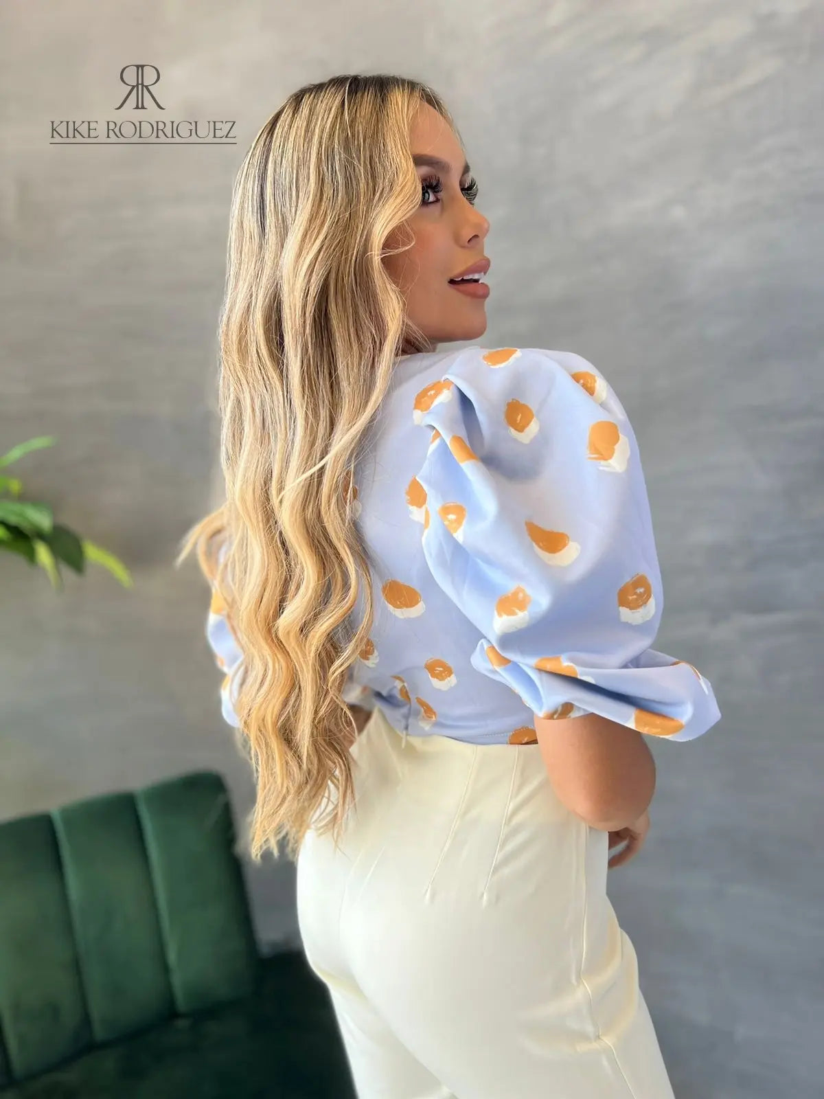 Mujer vistiendo un top azul con mangas abullonadas de KIKE RODRIGUEZ, ideal para un look moderno y original. Perfecto para destacar en cualquier ocasión especial.