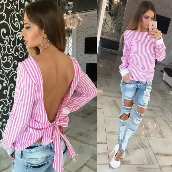 Mujer con blusa rosa con espalda descubierta disfrutando de una vista panorámica. Blusa ideal para un look casual y sofisticado. Disponible en KIKE RODRIGUEZ.