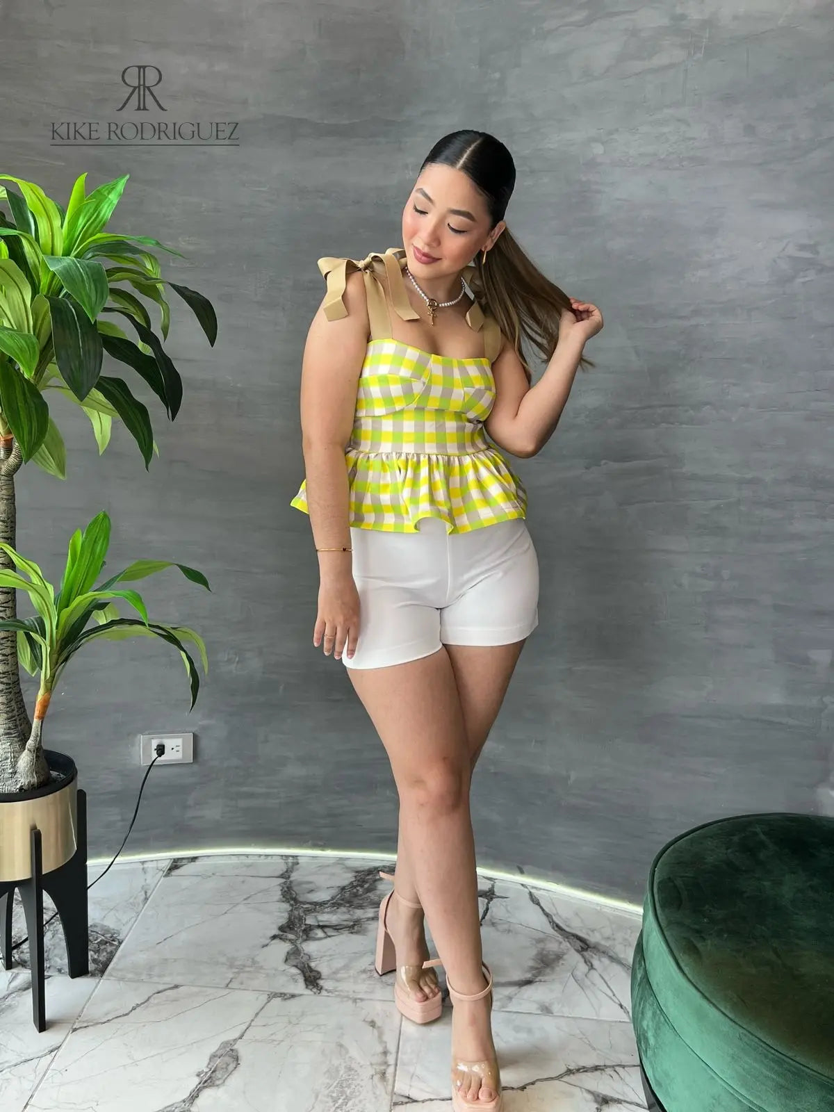 Mujer con una blusa de cuadros amarillos y volantes en descuento, mostrando un estilo alegre y moderno, perfecta para cualquier ocasión.