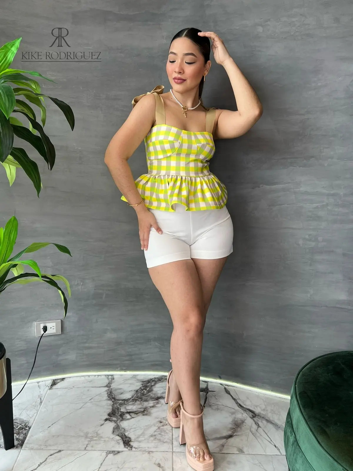 Mujer con una blusa de cuadros amarillos y volantes en descuento, mostrando un estilo alegre y moderno, perfecta para cualquier ocasión.