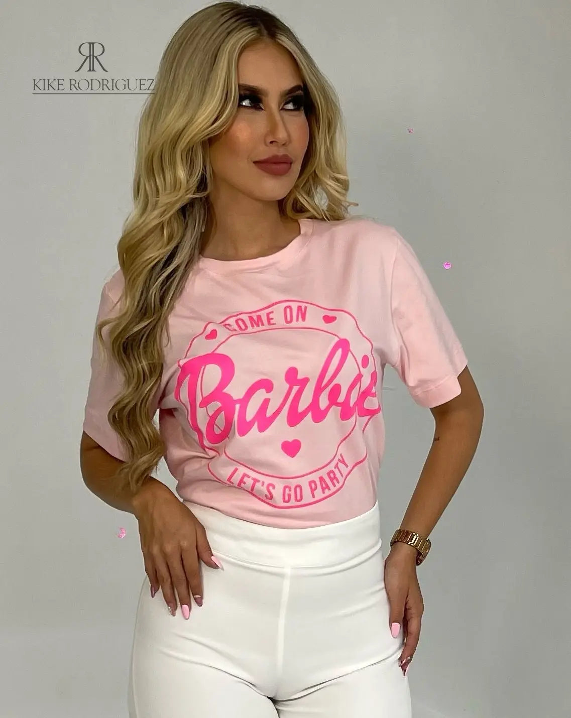 Camiseta rosa con diseño de Barbie "Let's Go Party" en promoción especial de 3 por $129,900. Ideal para un look casual y alegre, disponible en KIKE RODRIGUEZ.