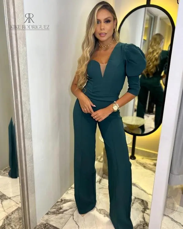 Modelo luciendo un elegante enterizo verde con escote en V y mangas abullonadas, ideal para eventos formales y ocasiones especiales.