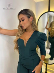 Modelo luciendo un elegante enterizo verde con escote en V y mangas abullonadas, ideal para eventos formales y ocasiones especiales.