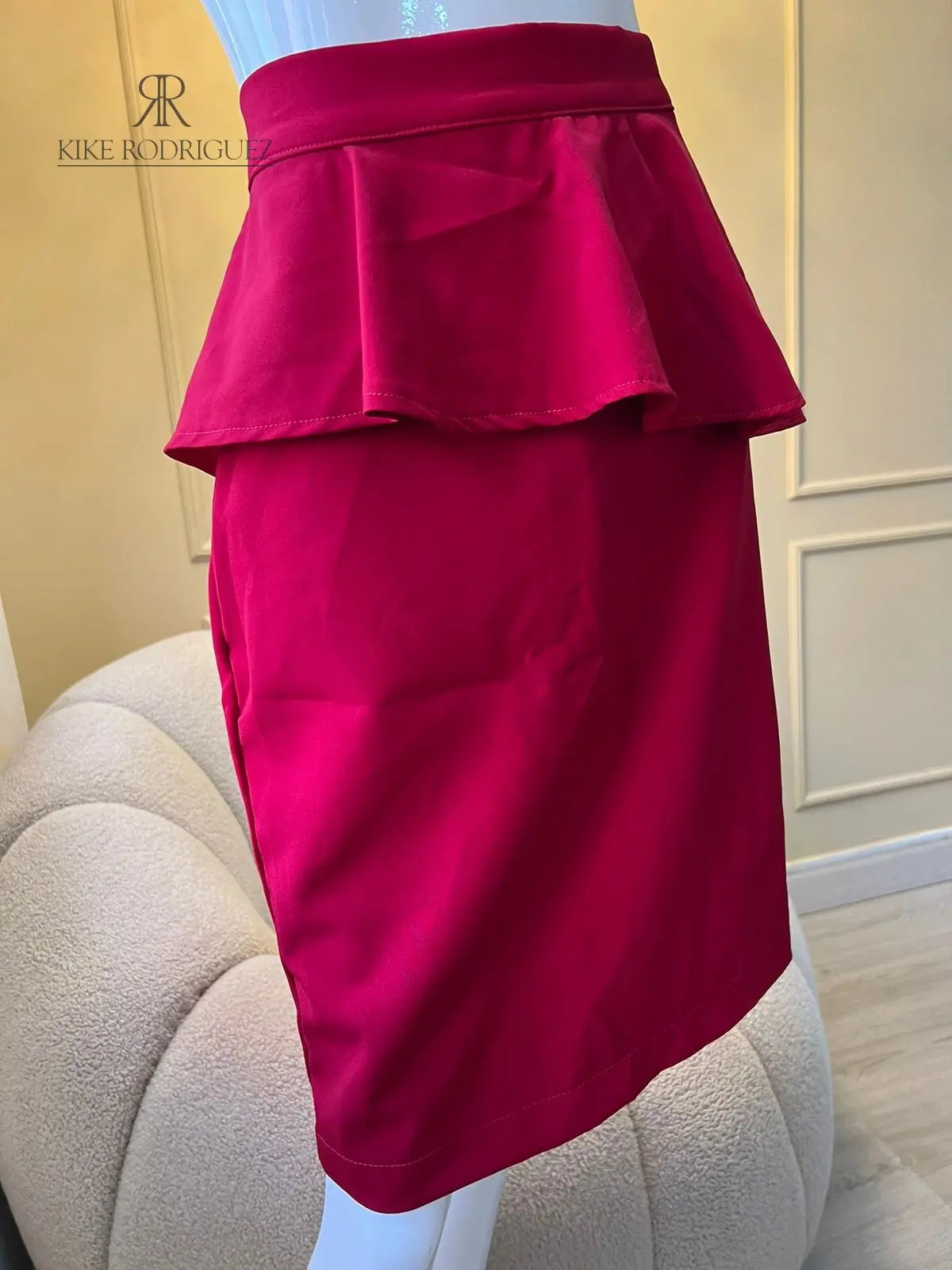 Falda roja con volante peplum, ideal para eventos y looks sofisticados. Diseño elegante y moderno de KIKE RODRIGUEZ.