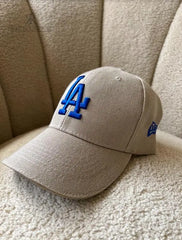 Gorra beige de Kike Rodriguez con logo azul de Los Angeles Dodgers, ideal para un look casual y moderno, perfecta para combinar con cualquier outfit diario