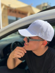 Hombre usando una gorra blanca de Kike Rodriguez con logo blanco de los New York Yankees, combinada con gafas de sol y camiseta negra para un look casual y moderno