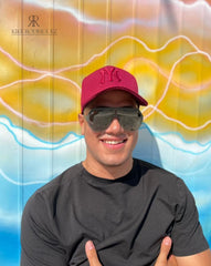 Hombre usando una gorra roja burdeos de Kike Rodriguez con logo en tono similar de los New York Yankees, combinada con gafas de sol y camiseta negra, ideal para un look casual y urbano