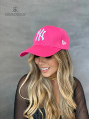 Mujer usando una gorra rosa de Kike Rodriguez con logo blanco de los New York Yankees, ideal para un look casual y moderno, perfecto para destacar con estilo