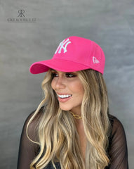 Mujer usando una gorra rosa de Kike Rodriguez con logo blanco de los New York Yankees, ideal para un look casual y moderno, perfecto para destacar con estilo