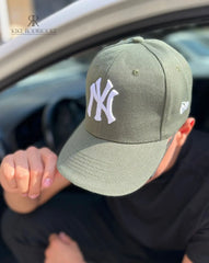 Hombre usando una gorra verde oliva de Kike Rodriguez con logo blanco de los New York Yankees, ideal para un look casual y moderno, perfecta para combinar con ropa urbana