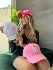 Mujer usando una gorra rosa de Kike Rodriguez con logo blanco de los New York Yankees, ideal para un look casual y moderno, perfecto para destacar con estilo