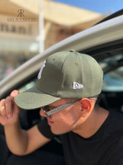 Hombre usando una gorra verde oliva de Kike Rodriguez con logo blanco de los New York Yankees, ideal para un look casual y moderno, perfecta para combinar con ropa urbana