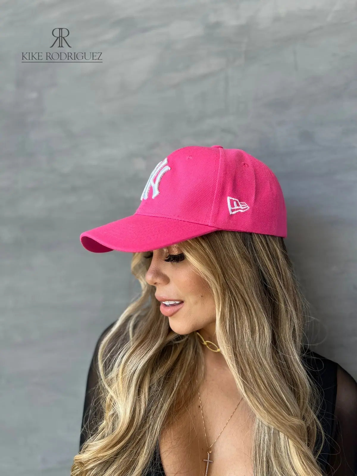 Mujer usando una gorra rosa de Kike Rodriguez con logo blanco de los New York Yankees, ideal para un look casual y moderno, perfecto para destacar con estilo