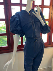 Maniquí luciendo un elegante mono azul con mangas abullonadas y cinturón ajustable, ideal para ocasiones especiales o salidas casuales con estilo.