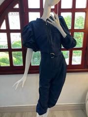 Maniquí luciendo un elegante mono azul con mangas abullonadas y cinturón ajustable, ideal para ocasiones especiales o salidas casuales con estilo.