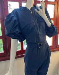 Maniquí luciendo un elegante mono azul con mangas abullonadas y cinturón ajustable, ideal para ocasiones especiales o salidas casuales con estilo.