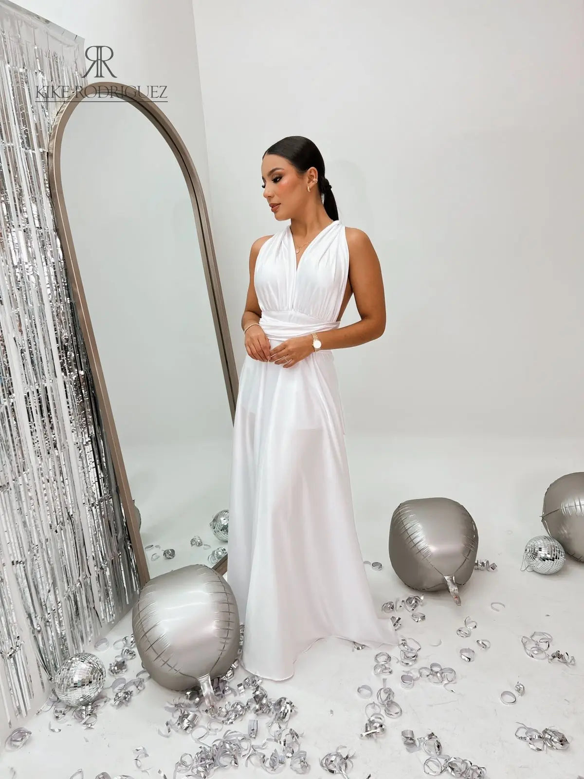 Modelo luciendo el Vestido Elegante Blanco de Kike Rodriguez, con diseño de cuello halter y abertura lateral, ideal para eventos formales y ocasiones especiales.