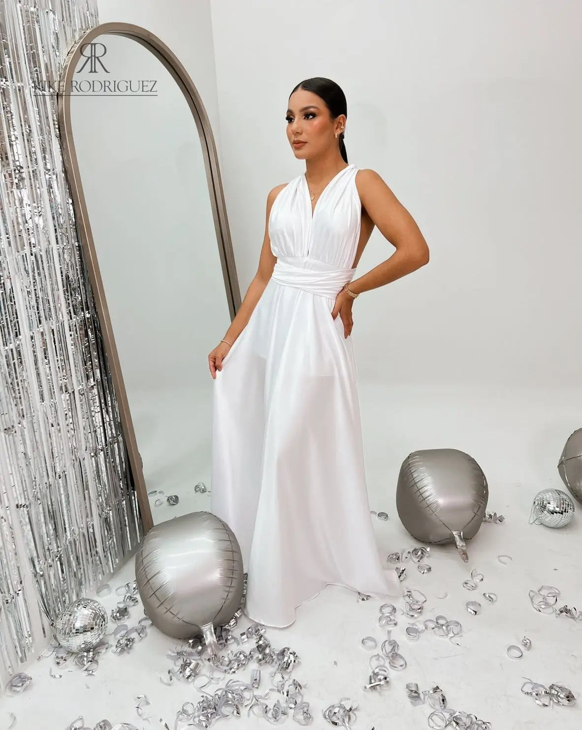 Modelo luciendo el Vestido Elegante Blanco de Kike Rodriguez, con diseño de cuello halter y abertura lateral, ideal para eventos formales y ocasiones especiales.