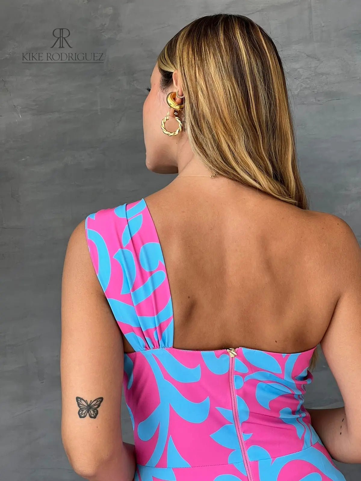 Mujer luciendo un vestido largo floral en rosa y azul de KIKE RODRIGUEZ, destacando elegancia y estilo para eventos especiales.