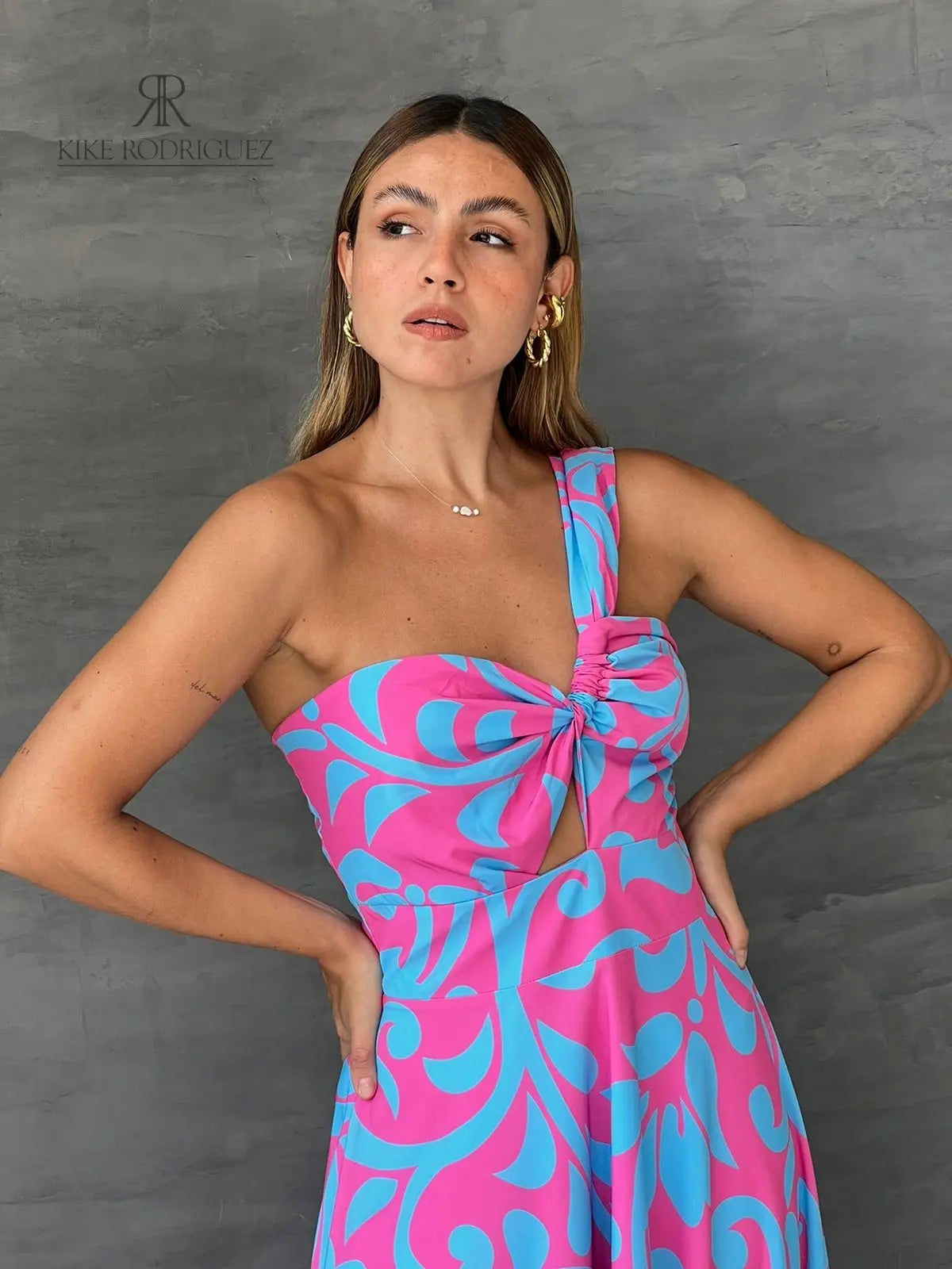 Mujer luciendo un vestido largo floral en rosa y azul de KIKE RODRIGUEZ, destacando elegancia y estilo para eventos especiales.