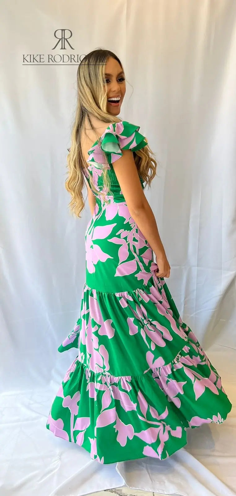Mujer vistiendo un elegante vestido largo verde estampado floral de KIKE RODRIGUEZ, ideal para eventos especiales y ocasiones elegantes.