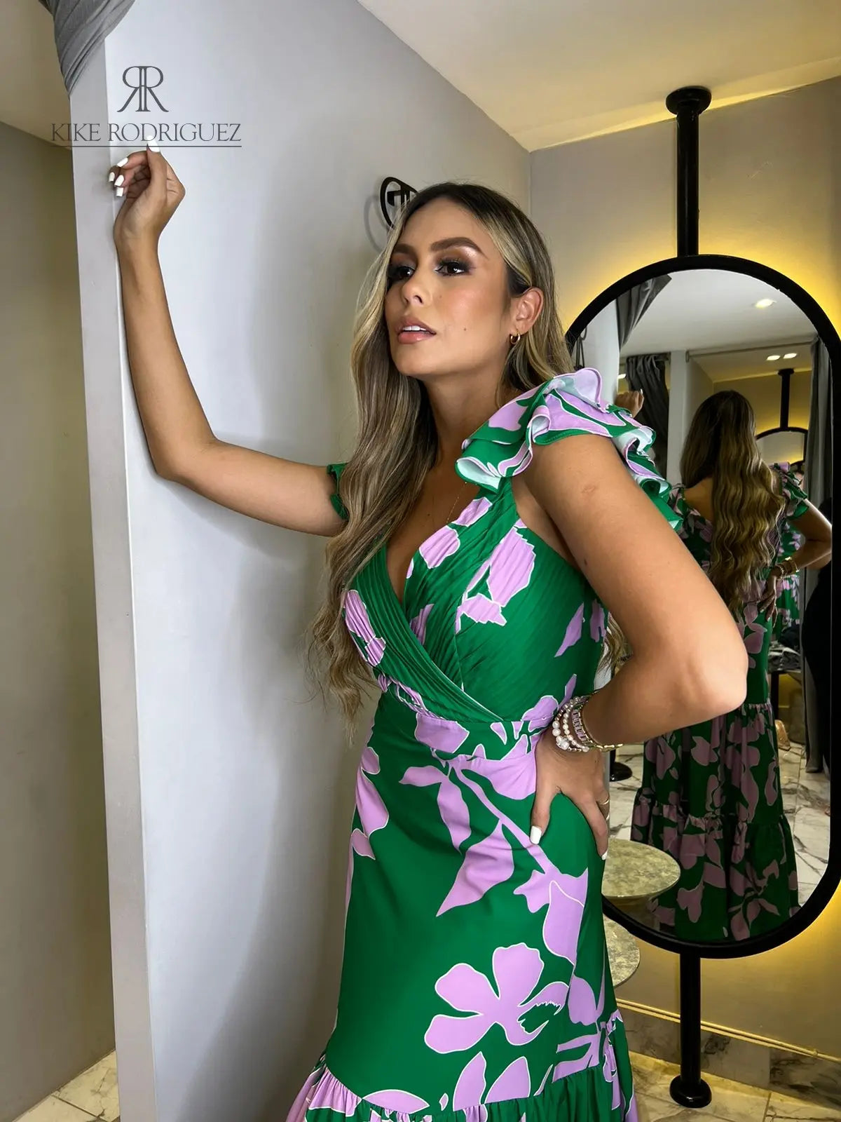 Mujer vistiendo un elegante vestido largo verde estampado floral de KIKE RODRIGUEZ, ideal para eventos especiales y ocasiones elegantes.