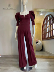 Enterizo burdeos elegante con escote cuadrado y mangas abullonadas, ideal para eventos formales.
