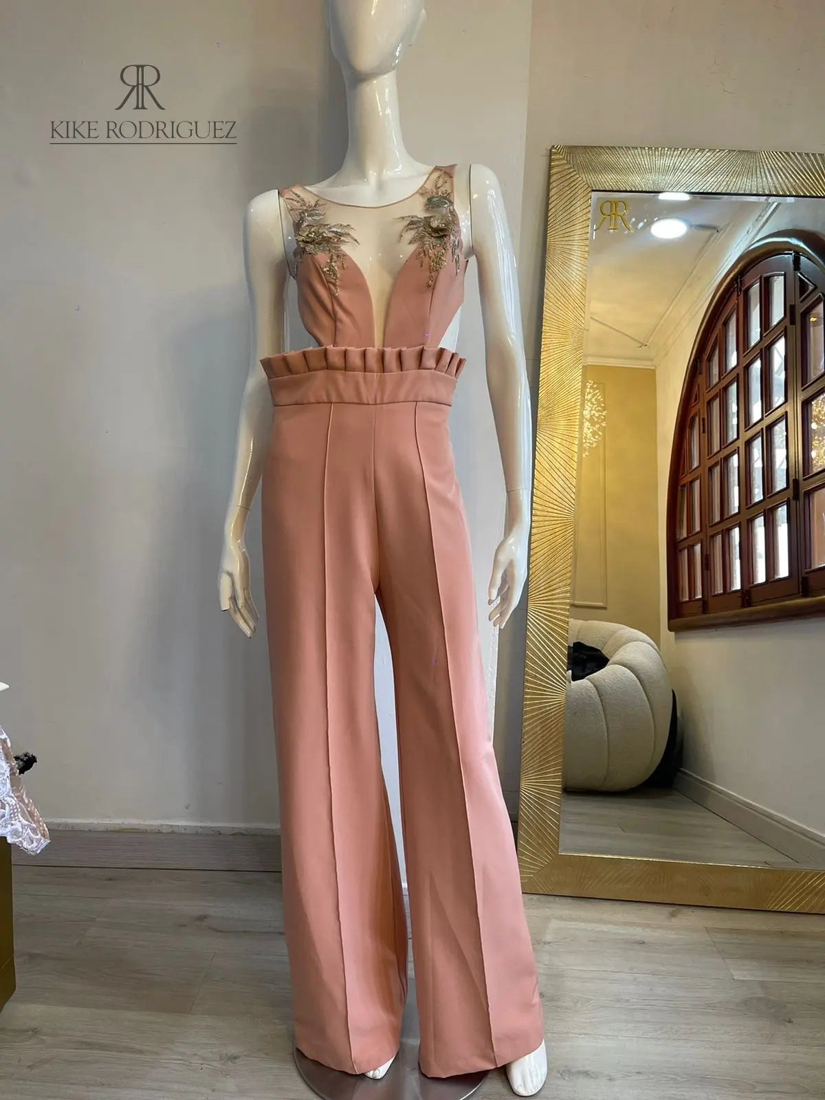 Enterizo rosa elegante con bordado floral en el escote y cintura acanalada visto desde el frente