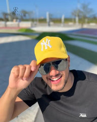 Hombre sonriente con gorra deportiva NY de color amarillo, modelo de KIKE RODRIGUEZ, ideal para un look casual y moderno.