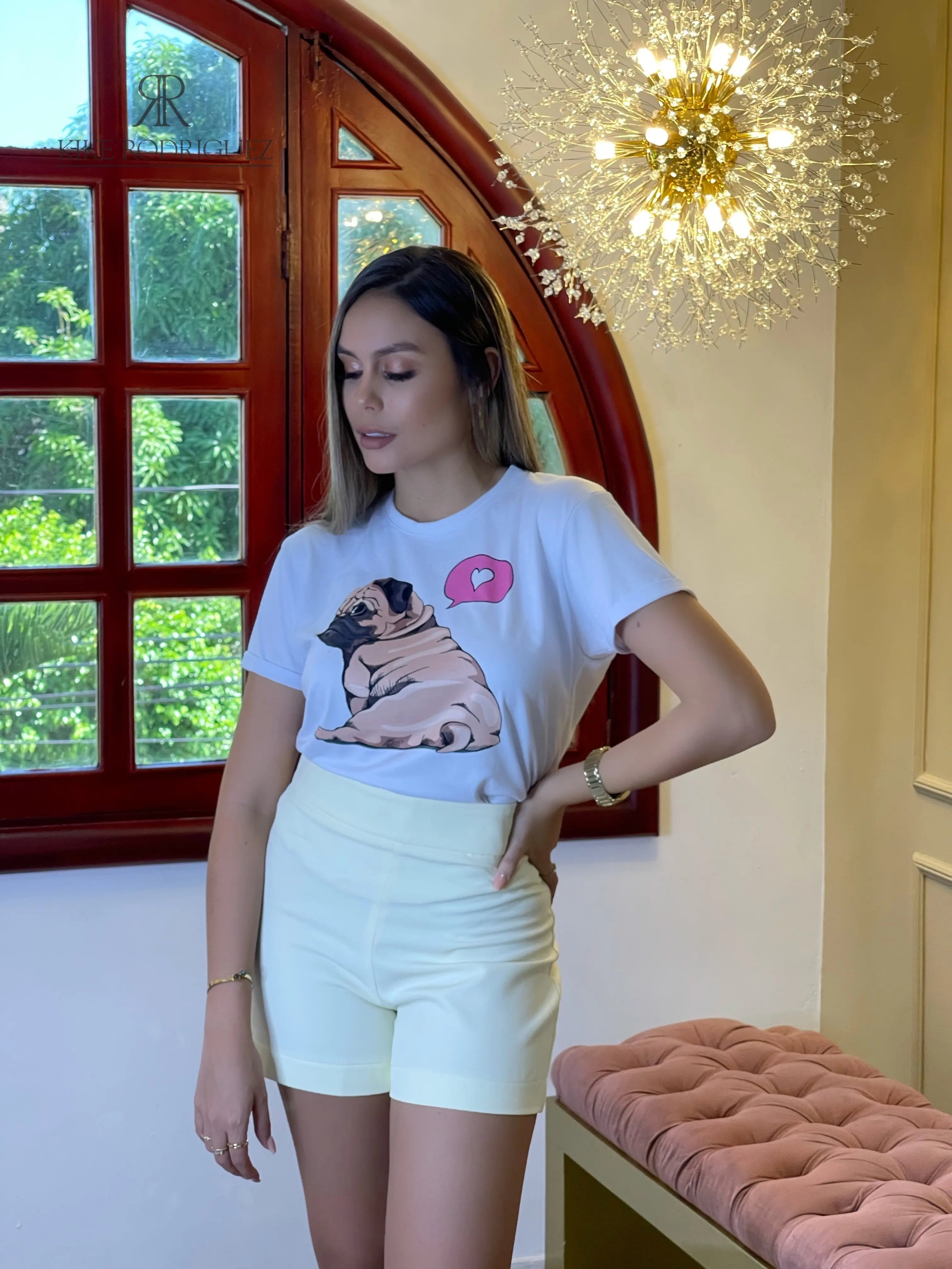 Camiseta blanca con estampado de un Pug y detalle de corazón, ideal para los amantes de los perros. Disponible en promoción de 3 por $129,900 en KIKE RODRIGUEZ. ¡Compra ahora y luce un estilo encantador!